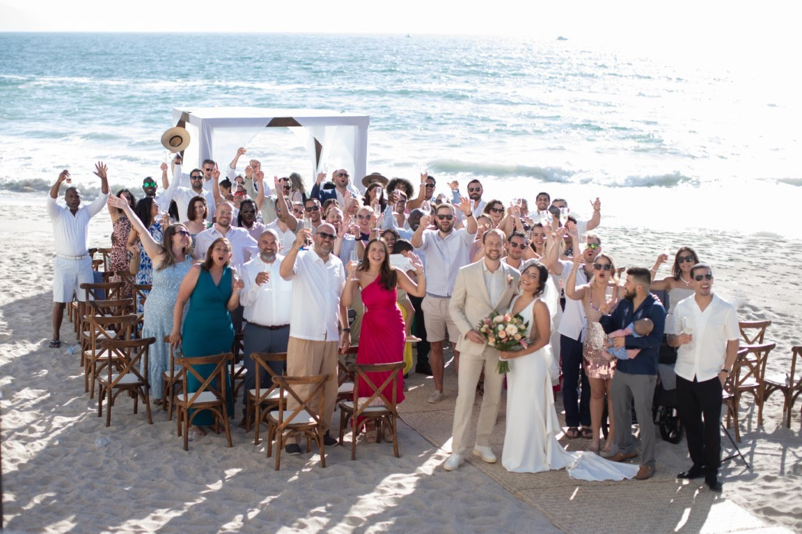 Destination wedding group celebrating on the beach
