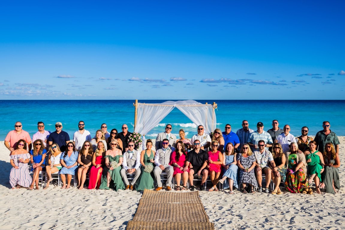 Wedding guests seated on beach with turquoise ocean view