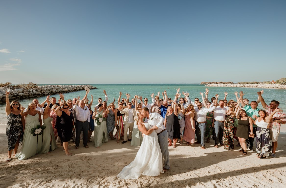 Bride and groom kissing in front of destination wedding guests