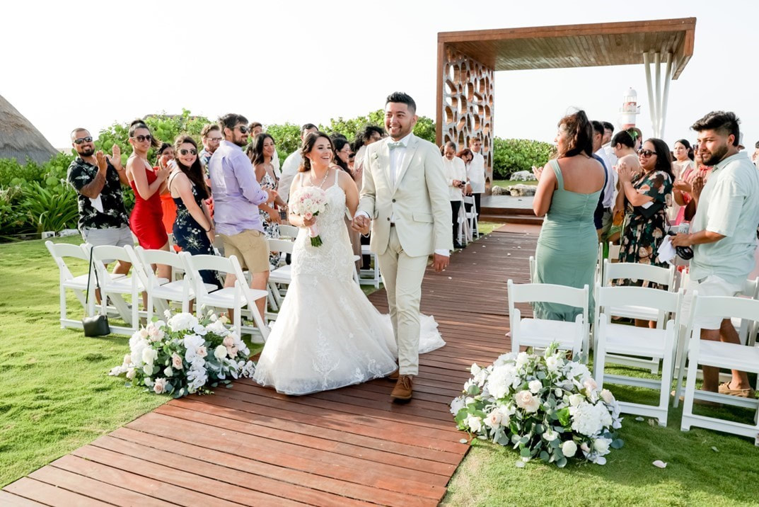 Newlyweds walking down the aisle after a tropical destination wedding