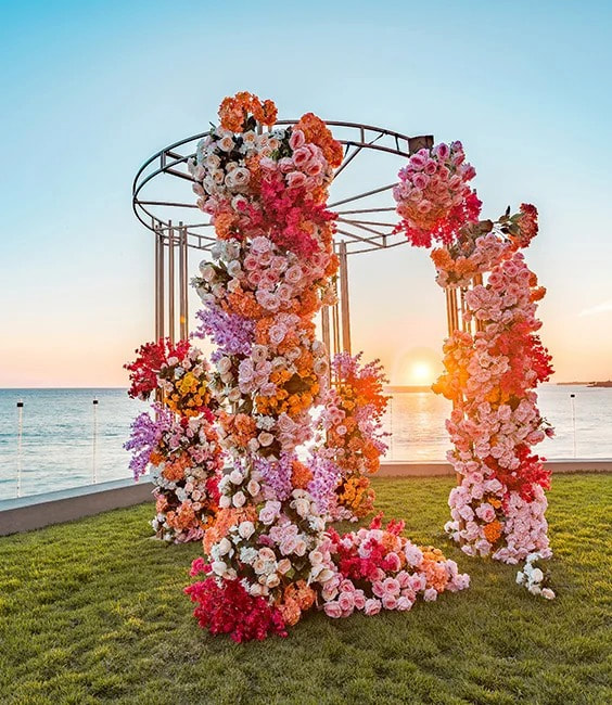 Colorful floral wedding installation by the ocean
