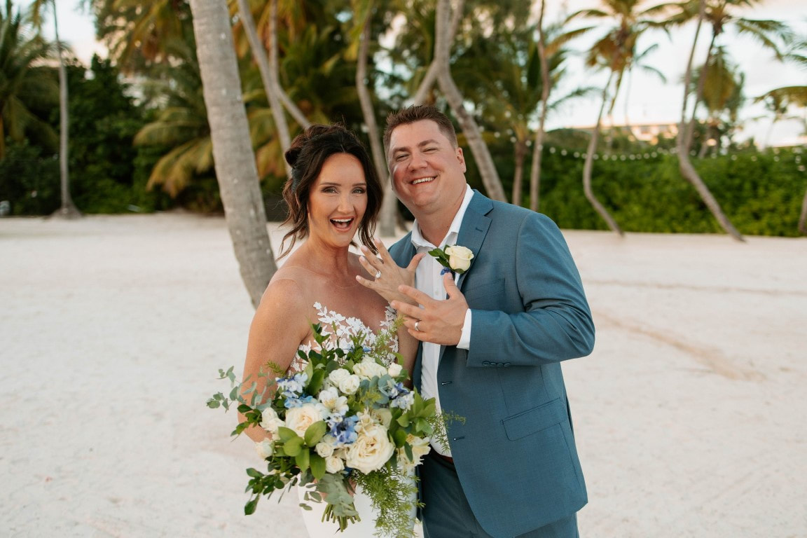Destination wedding couple showing wedding rings on the beach