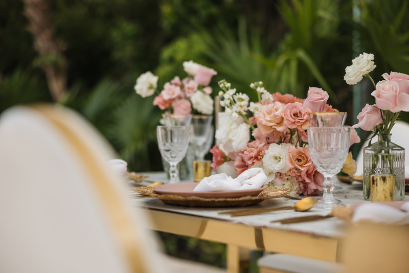Destination wedding reception table with pink floral centerpiece